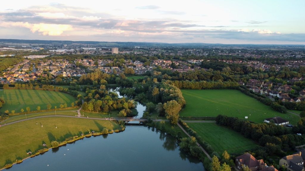Milton Keynes Tops UK Green Space Rankings aerial view of green grass field near lake during daytime