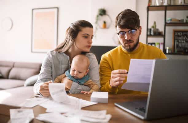The Biggest Financial Challenges Facing UK Families in 2026 A British couple reviewing financial bills and energy statements at a kitchen table in 2026. cost of living uk 2026